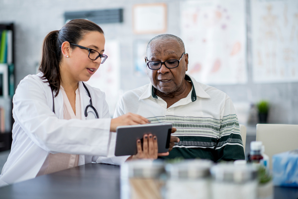 Provider showing older male test results on tablet